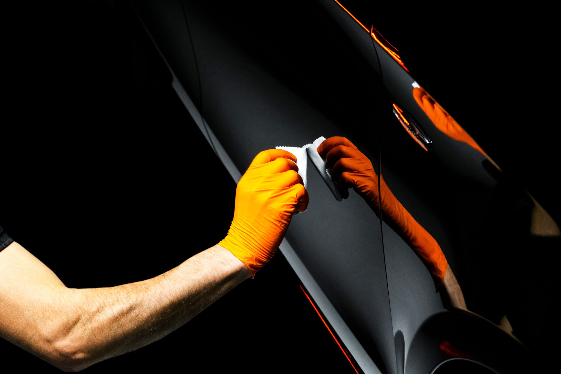 Car polish wax worker hands polishing car. Buffing and polishing vehicle with ceramic. Car detailing. Man holds a polisher in the hand and polishes the car with nano ceramic. Tools for polishing